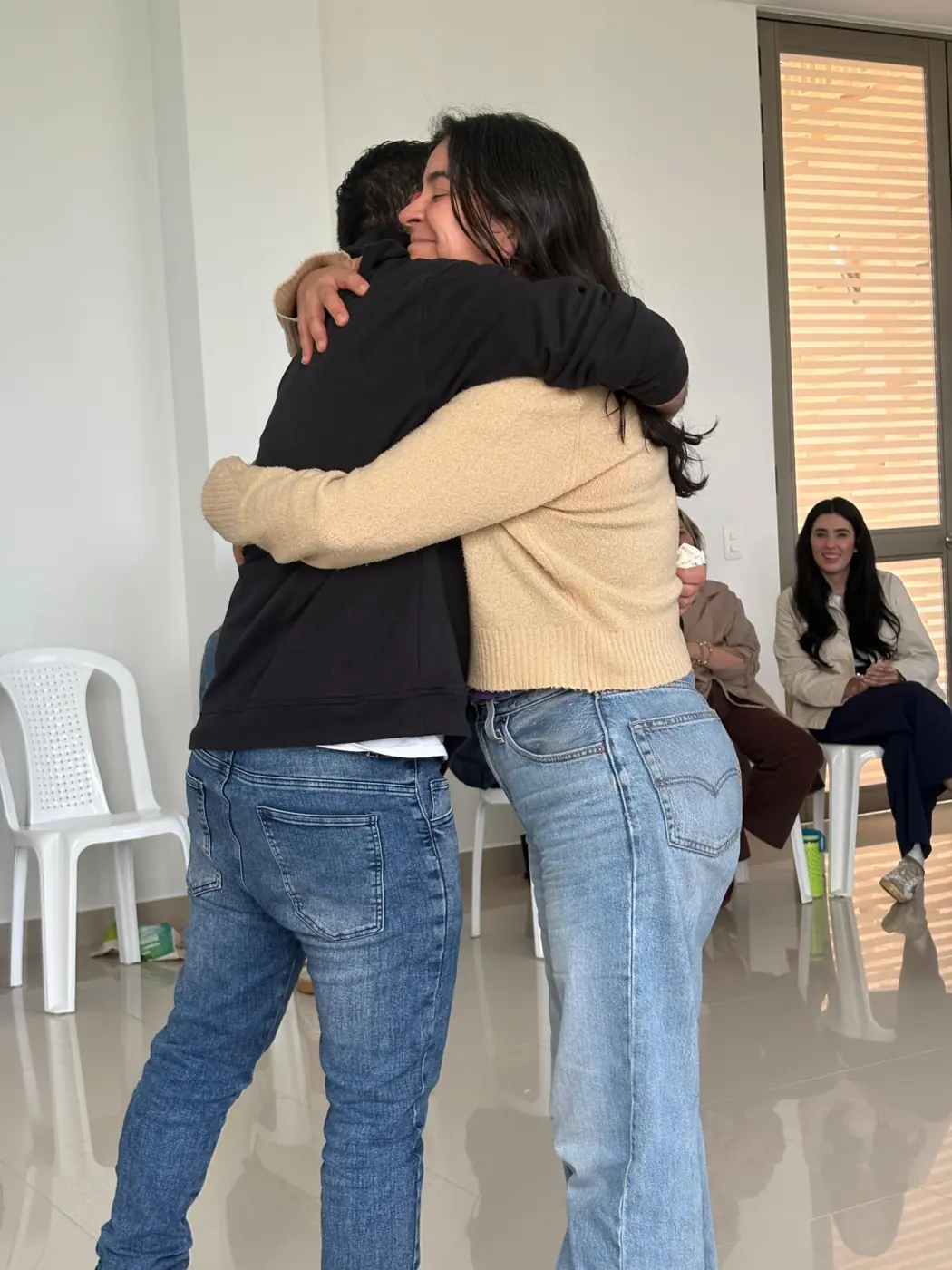Dos participantes se abrazan al cierre de una constelación