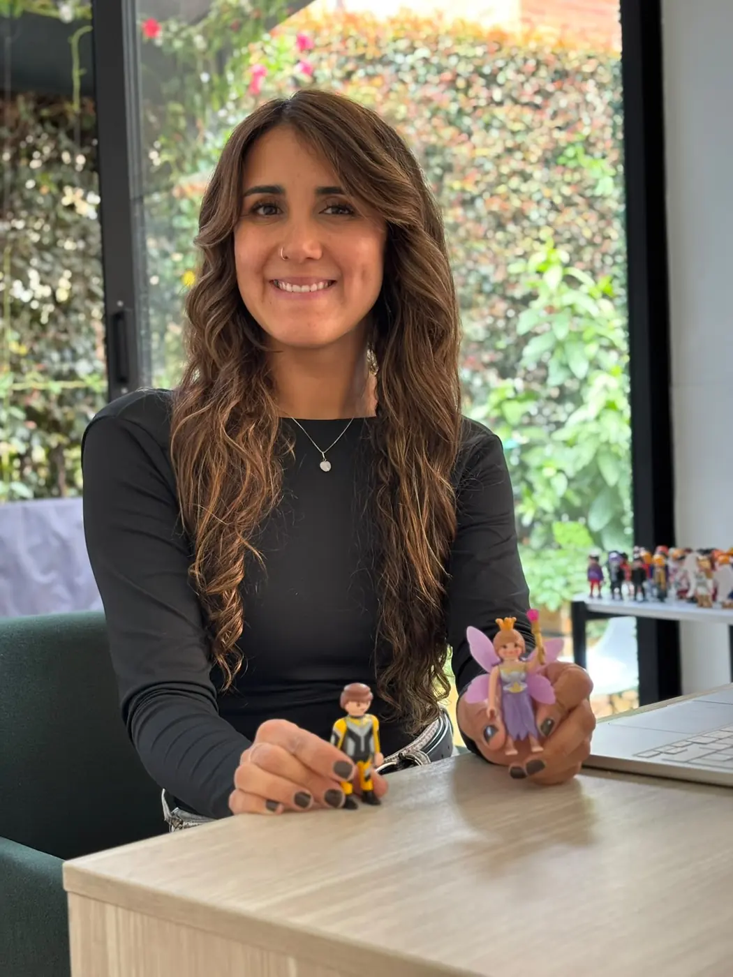 Nikole Forero en su consultorio, con dos de las figuras que usa en las constelaciones individuales